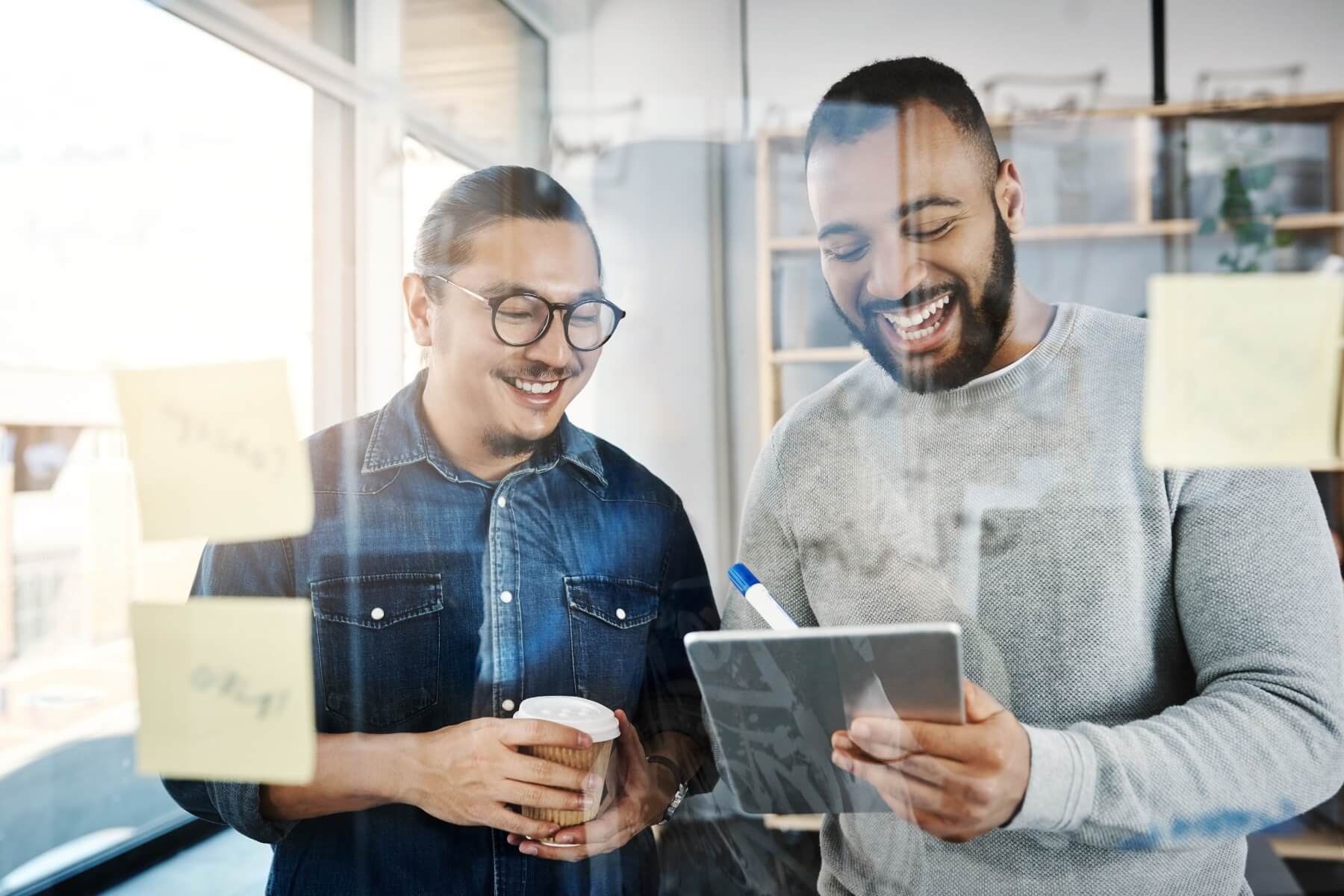 Financial consultant and client enthusiastically gathering over a white board 